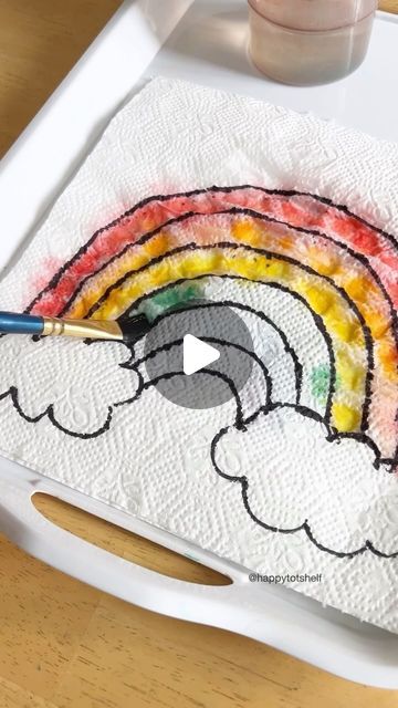 a child's drawing with crayons on a paper towel and paintbrush