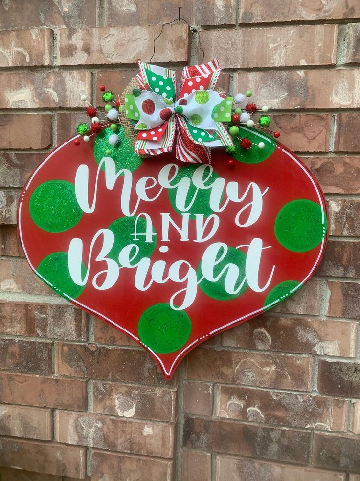 a merry and bright sign hanging on the side of a brick wall