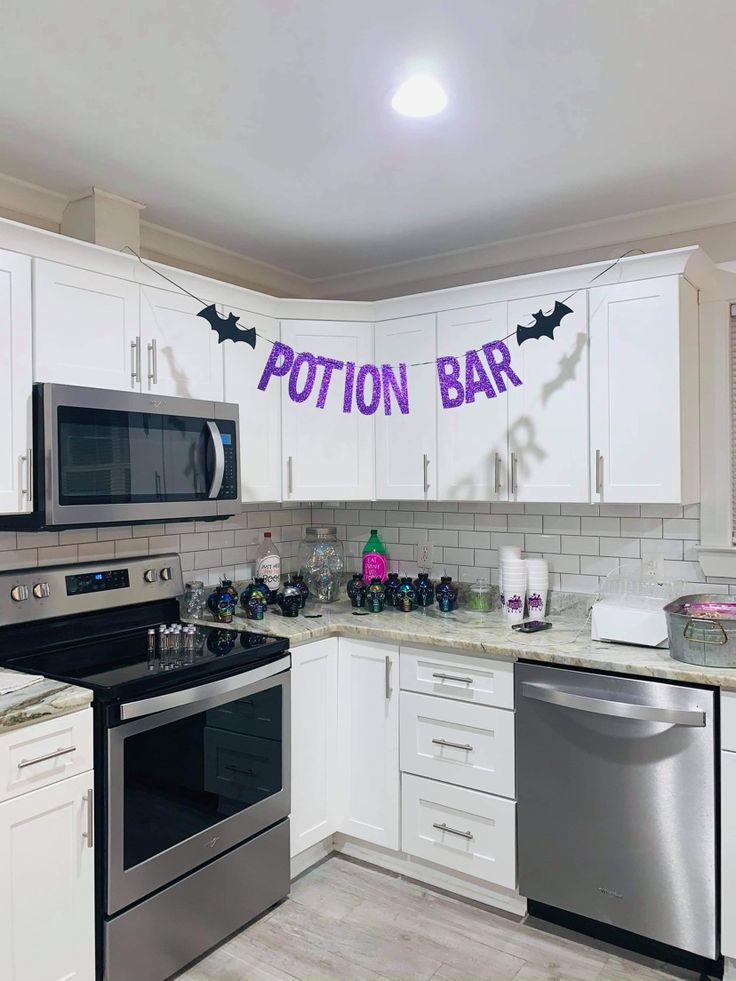 the kitchen is decorated for halloween with purple and black decorations on the wall above the stove