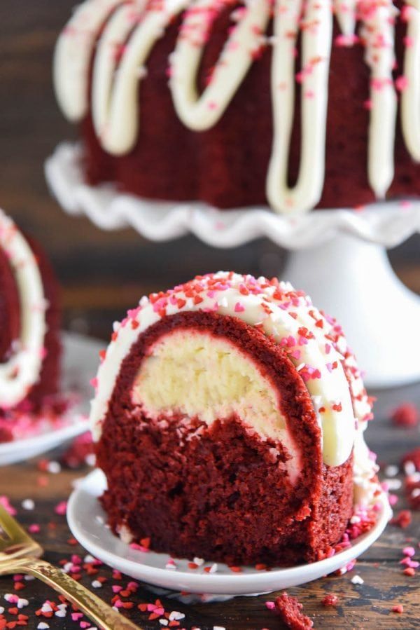 a red velvet cake with white frosting and sprinkles on a plate