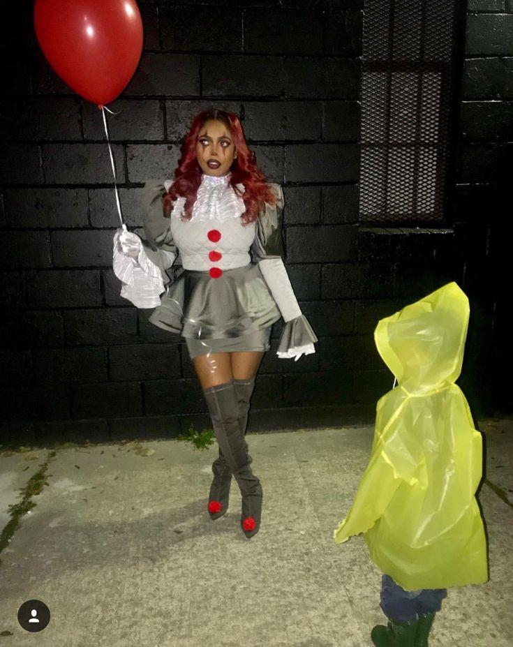 a woman dressed as a clown holding a red balloon