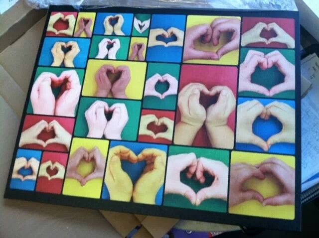 several hands making a heart shape in front of a box with other hand prints on it