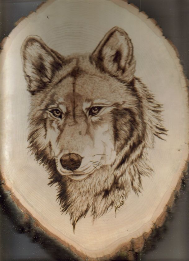 a drawing of a wolf's head on a piece of wood that has been carved into it