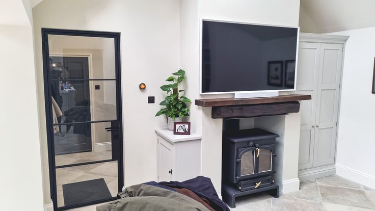 a flat screen tv sitting on top of a wooden stand in a living room next to a fireplace