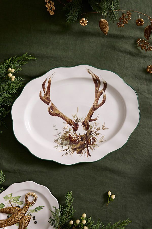 two plates decorated with deer antlers and pine cones