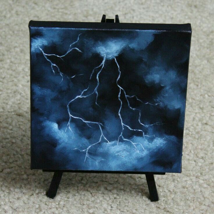 a miniature easel with a painting of a lightning bolt