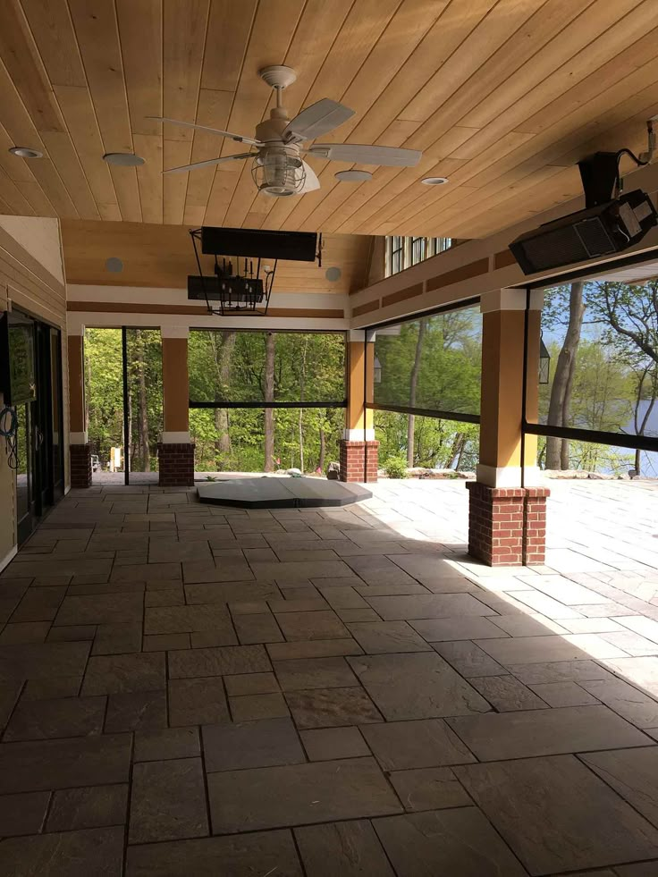 an empty patio with ceiling fans and windows