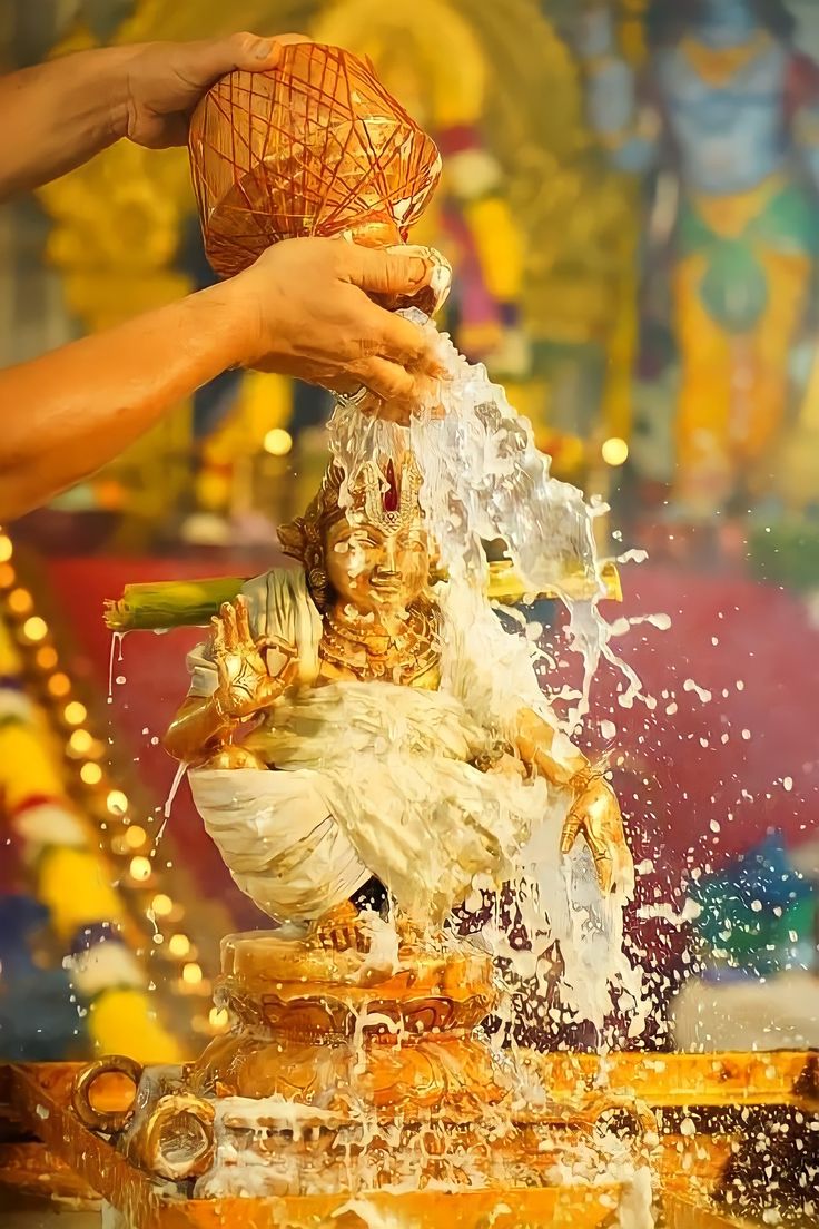 a person is pouring water onto a statue