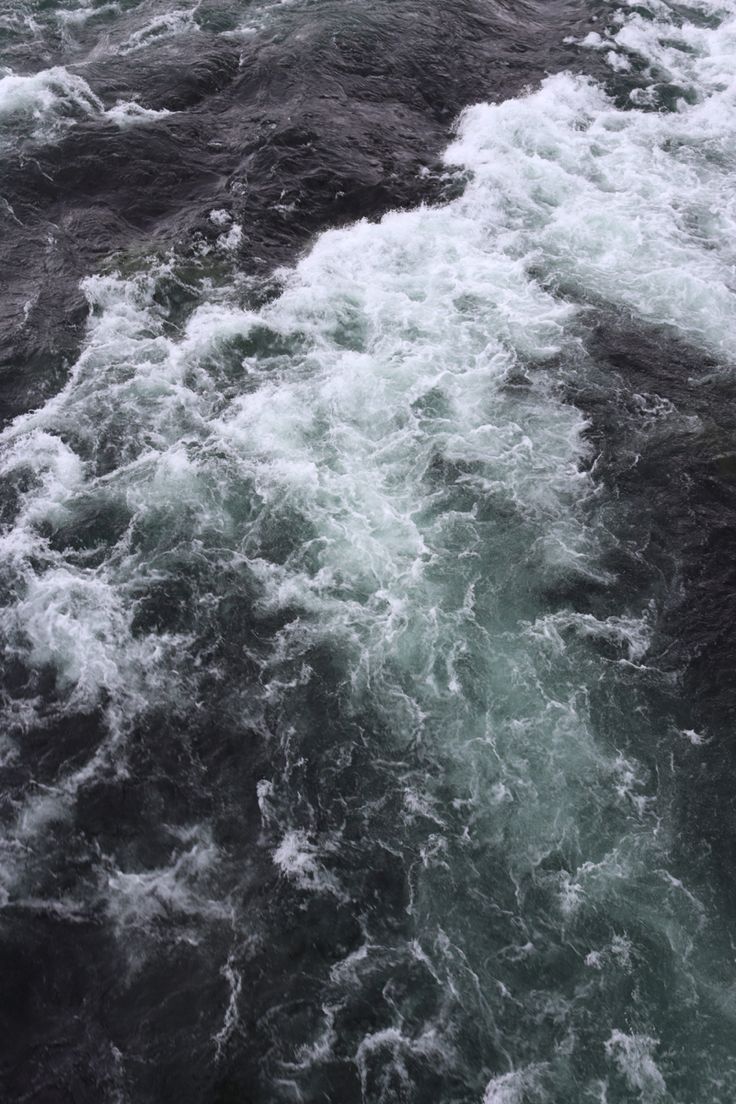 the water is choppy and foamy as it moves through the rocks in the river