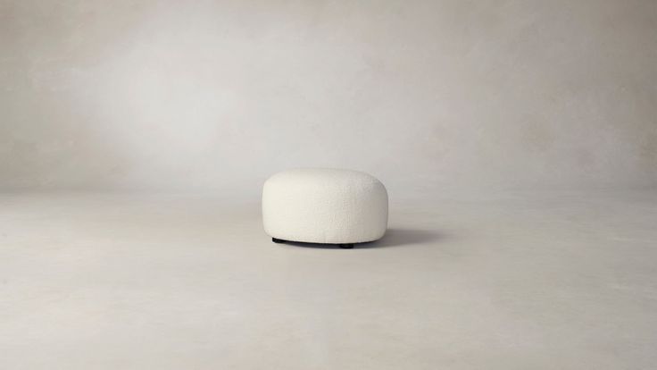 a small white object sitting on top of a cement floor in front of a wall