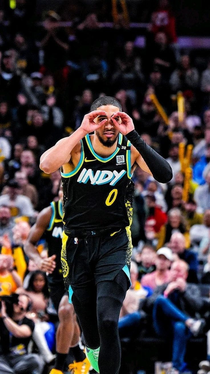 a basketball player with his hand up in the air as he walks down the court