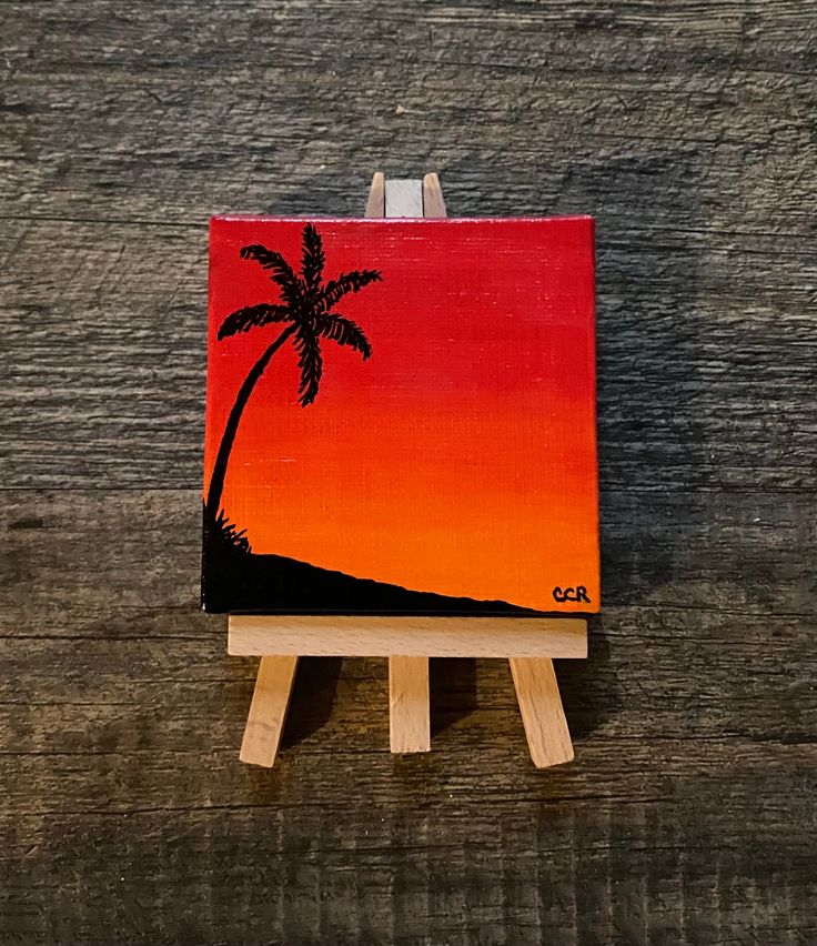 an easel with a painting on it and a palm tree painted on the side