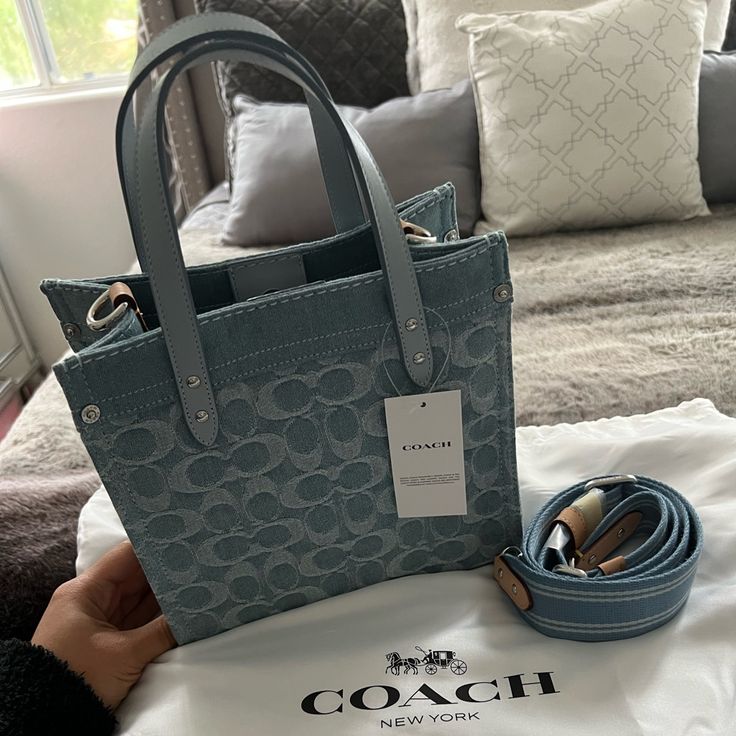 Coach Field Tote 22in Denim Collection. New With Tags. Has Dustbag. Has Strap. Signature Denim And Refined Calf Leather Inside Zip Pocket Snap Closure, Fabric Lining Handles With 4" Drop Detachable Strap With 24 1/2" Drop For Shoulder Or Crossbody Wear Four Protective Feet At Base 8 3/4" (L) X 8 1/4" (H) X 4 3/4" (W) Style No. Cj853 Blue Denim Shoulder Bag With Handles, Trendy Denim Bags With Dust Bag Included, Everyday Denim Blue Bags With Branded Hardware, Designer Everyday Bags In Denim Blue, Designer Denim Tote Bag, Designer Denim Blue Shoulder Bag For Everyday, Luxury Denim Bags For Shopping, Everyday Denim Shoulder Bag, Designer Denim Blue Shoulder Bag