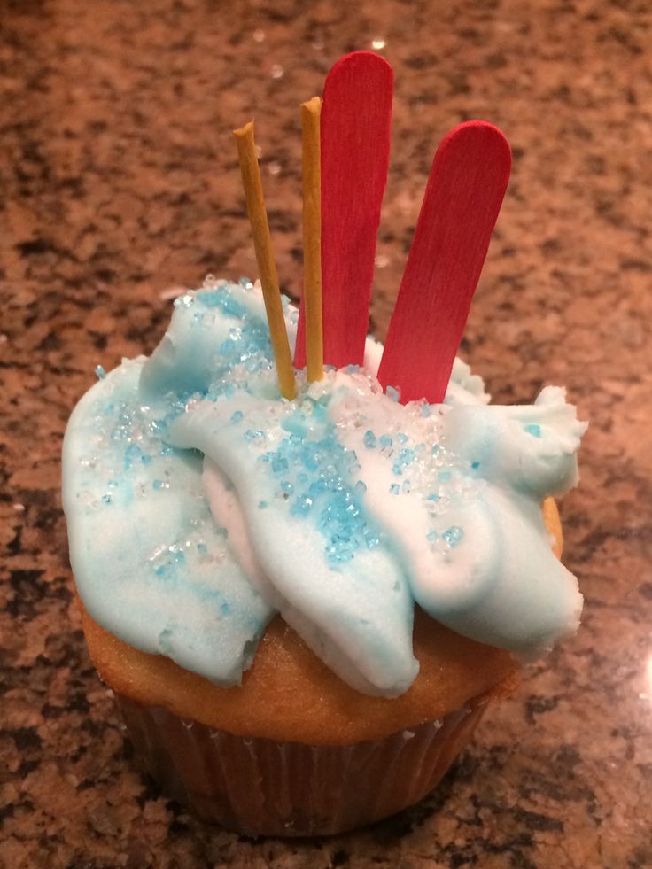 a cupcake with blue frosting and red sticks sticking out of it's top