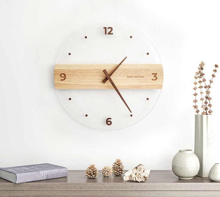 a clock on the wall next to vases and other items in front of it