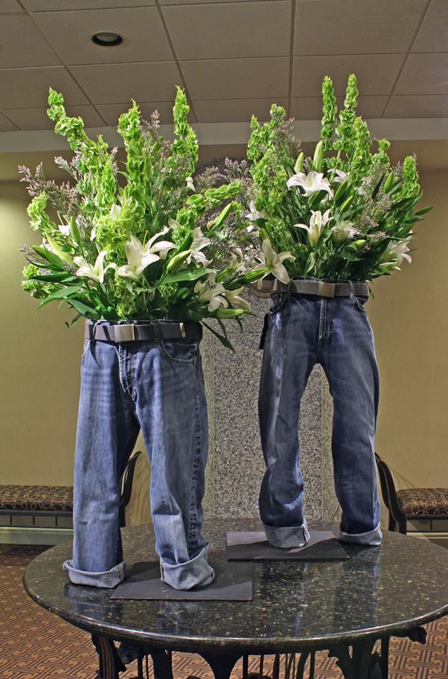 two pairs of jeans with flowers in them sitting on a table