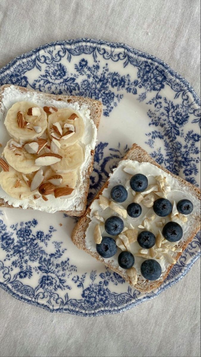 two pieces of bread with blueberries and bananas on them are sitting on a plate