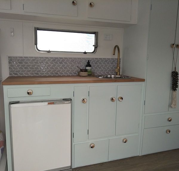 a kitchen area with white cabinets and a dishwasher