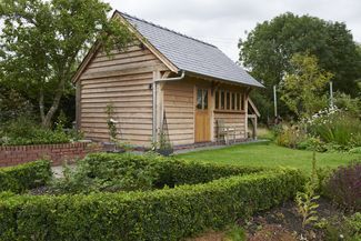 a small wooden building sitting in the middle of a garden