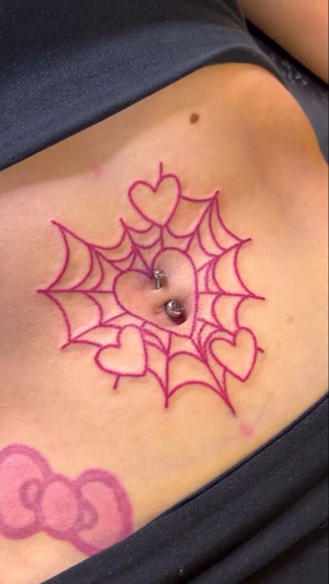 a spider web tattoo on the side of a woman's stomach, with hearts