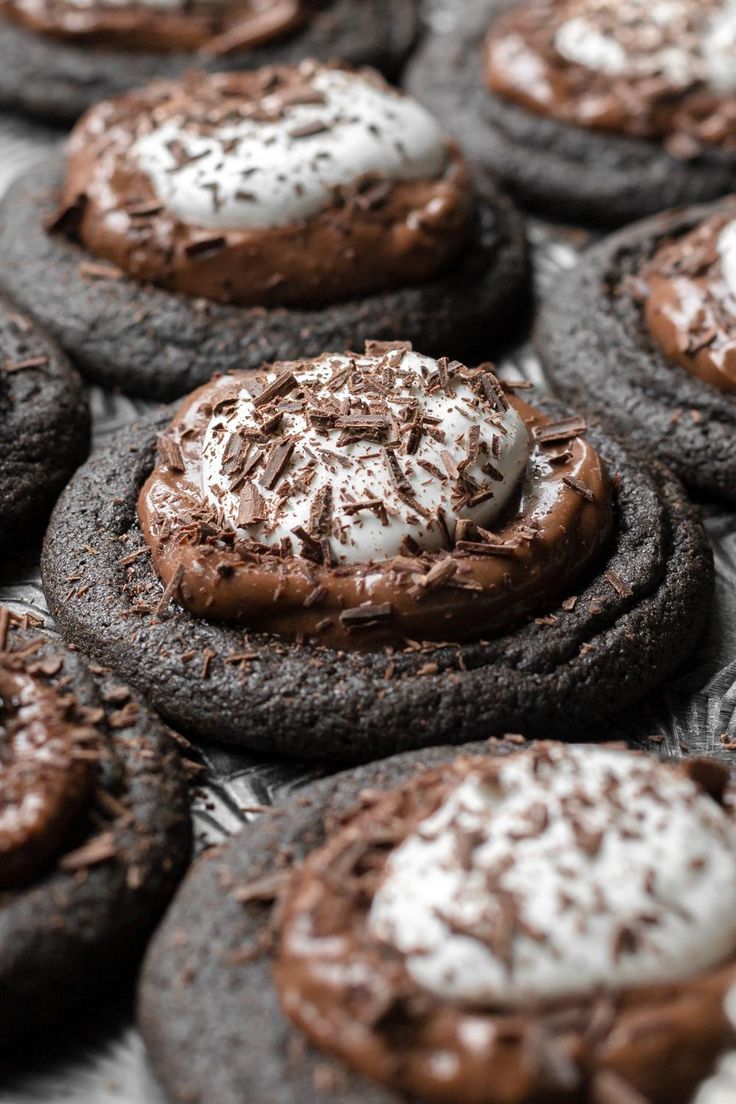 chocolate cookies with white frosting and sprinkles