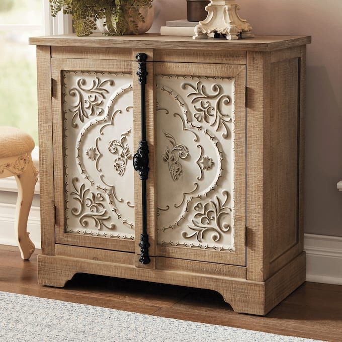 a wooden cabinet with ornate carvings on the doors and drawers, in a living room