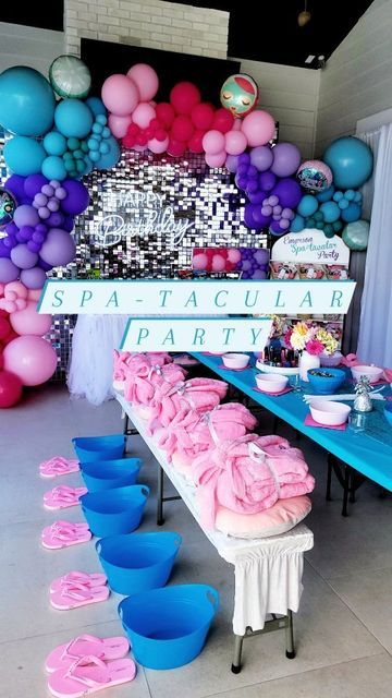 a birthday party with balloons and decorations on the wall, including pink and blue tablecloths