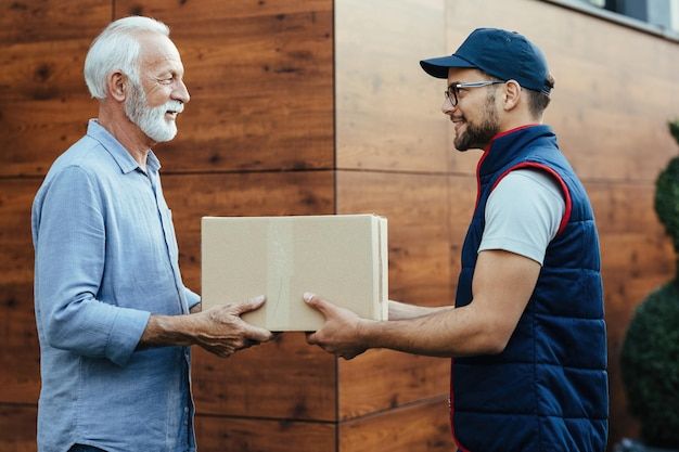 an older man receiving a box from another man