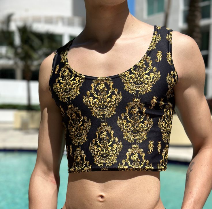 Elevate your beach style with our sleek and elegant men's Gold Baroque crop tank top, designed to perfectly complement Maris Equi swimshorts and swim briefs. Crafted for comfort and style, this coordinated ensemble is your go-to choice for beachside adventures or poolside lounging. Our men’s tank tops are made after you order. Allow 9 to 12 days for delivery. If you also order swim briefs, the tank will ship separately. This tank top has a unique and sexy drape over your torso. Pay attention to Gold Baroque, Elegant Man, Swim Brief, Crop Tank Top, Mens Gold, 12 Days, Beach Style, Spandex Fabric, Cropped Tank Top