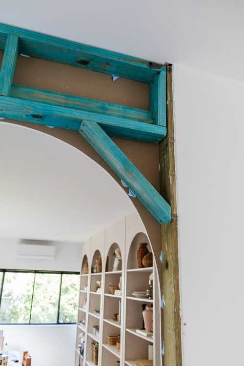 an arch in the wall between two shelves