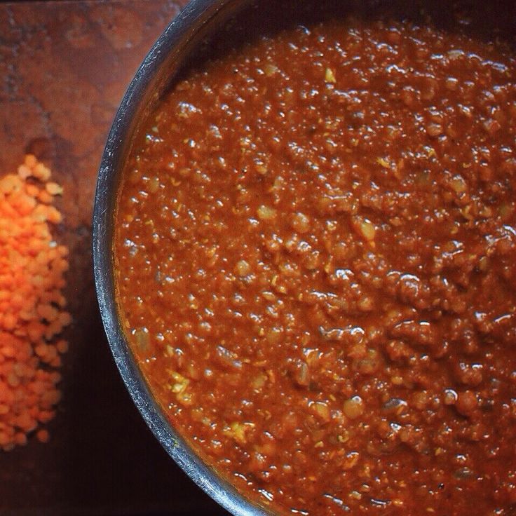 a bowl filled with chili next to a pile of rice