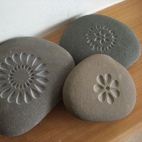 three rocks with designs on them sitting on a table