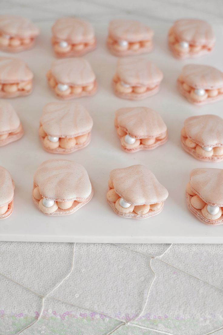 there are many cookies that have been decorated with pink icing and white frosting