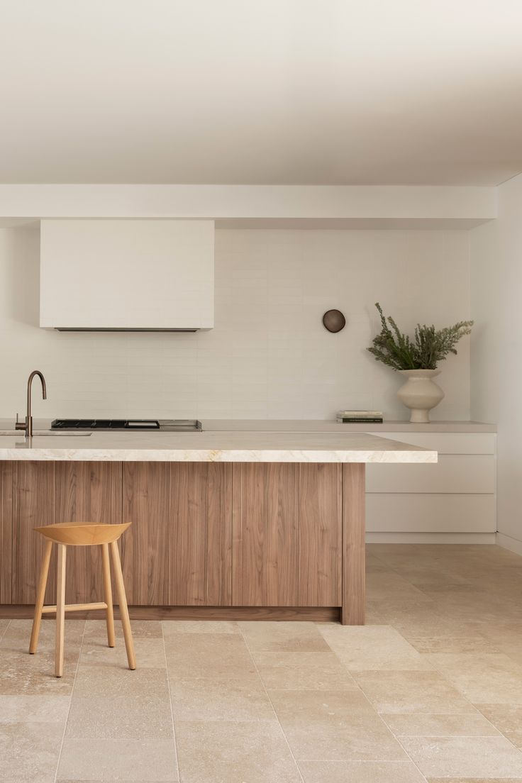 a modern kitchen with an island counter and stools in front of the stove top