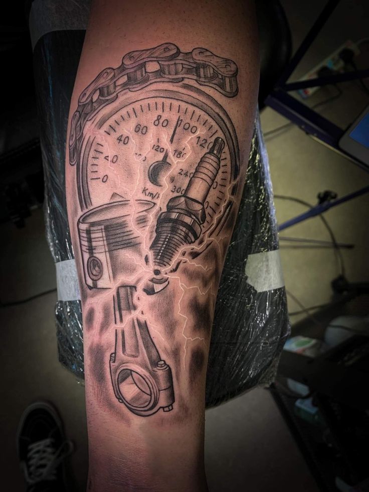 a man with a tattoo on his arm that has a speedometer and wrench