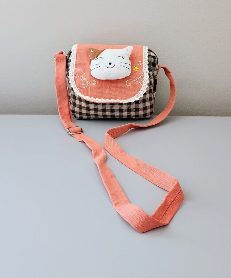 This QQ Pet crossbody bag is perfect for everyday use. The small size, measuring 5x7x4 inches, makes it convenient to carry around while still fitting all of your essentials. The bag is made of cotton material with a checkered pattern and features a unique design of QQ Pet characters, flowers, animals, and anime themes. The bag has a zip-around closure, a crossbody strap made of denim material, and a hidden compartment. It also includes a mobile phone pocket, limited edition print, wristlet, and padded features to protect your belongings. The lining is made of salmon-colored fabric and the bag comes in a unit quantity of 5. This QQ Pet crossbody bag is handmade and a must-have addition to your collection. Knit Bag, Cross Body Handbag, Colored Fabric, Denim Material, Checkered Pattern, Knitted Bags, Limited Edition Prints, Crossbody Strap, Cross Body Handbags