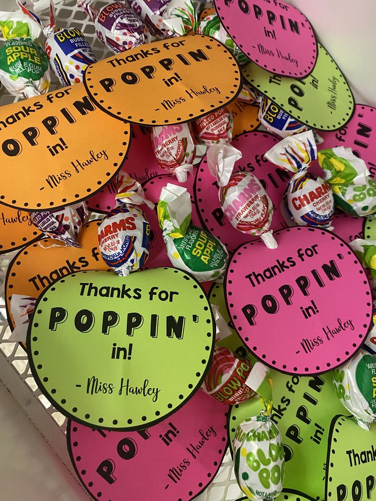 many different colored signs are on display in a white basket with pink, green and yellow tags