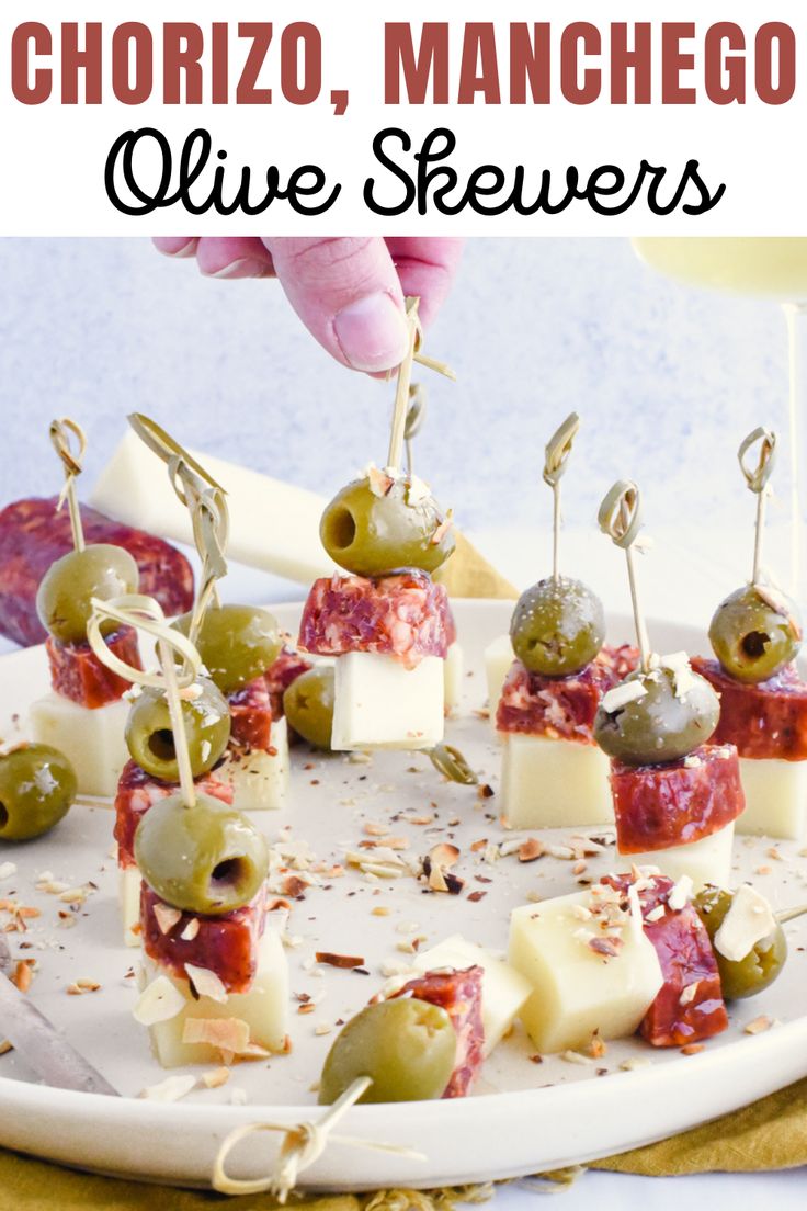 mini olive skewers on a white platter with text overlay that reads, chorizo, manchego olive skewers