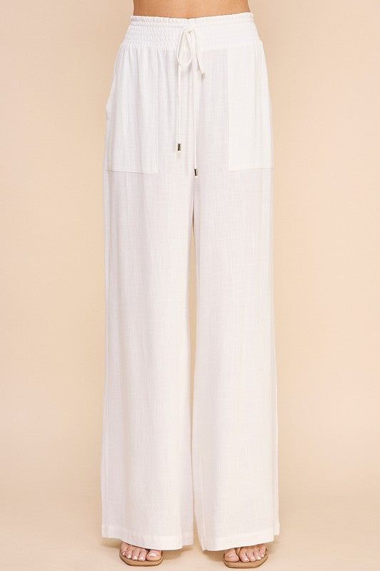 Stay comfortable and stylish in our Linen Wide Leg Pants! Made from soft linen, these pants feature a smock waist and wide leg design for a laid-back yet chic look. With convenient pockets, these pants are both practical and fashionable. Perfect for any casual occasion. Chic Summer Pull-on Style Pants, Chic Linen Pull-on Pants, Chic Linen Bottoms With Elastic Waistband, Chic Linen Wide Leg Pants With Pull-on Style, Relaxed Wide-leg Pants With Side Pockets, Chic Linen Loungewear Bottoms, Chic Linen Bottoms For Loungewear, Linen Pants With Elastic Waistband For Loungewear, Chic Wide Leg Loungewear Pants With Pull-on Style