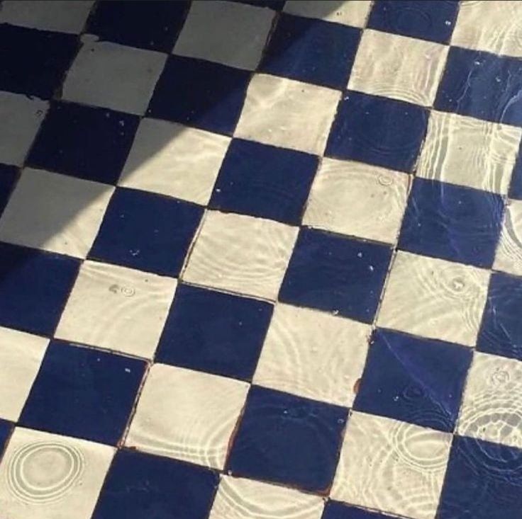 a black and white checkered floor with water on it