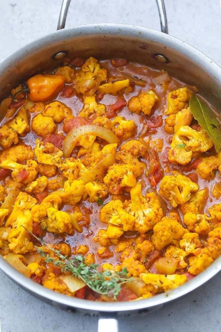 cauliflower and other vegetables are in a pot on the stove top, ready to be cooked