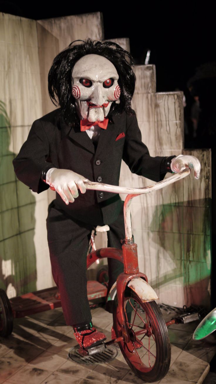 a creepy clown riding a tricycle in the dark