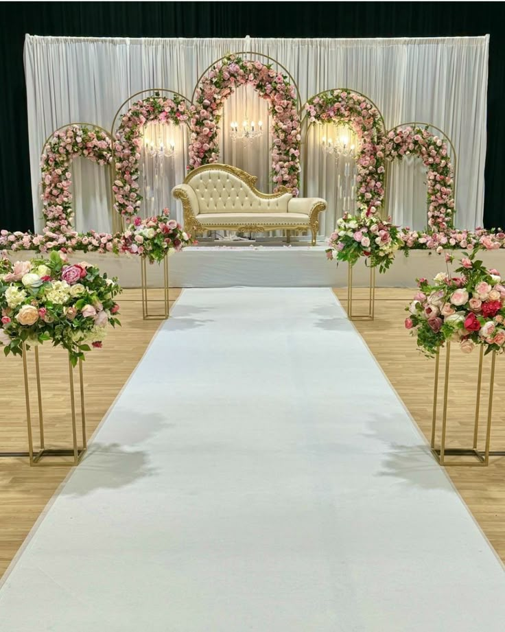 a wedding ceremony setup with flowers on the aisle