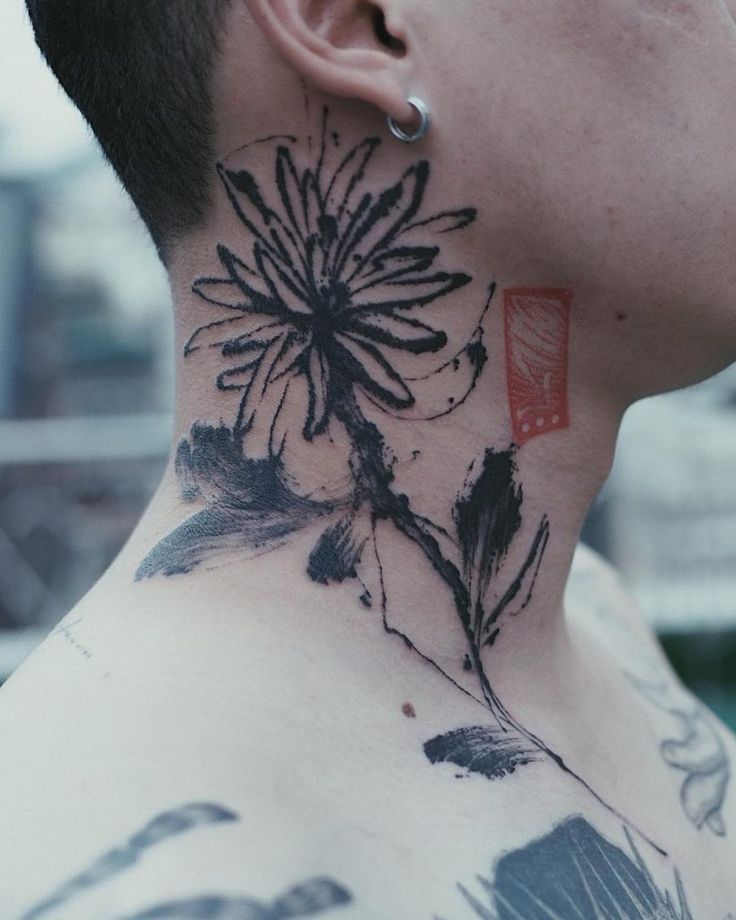 a man with a tattoo on his neck and behind his ear is a dandelion