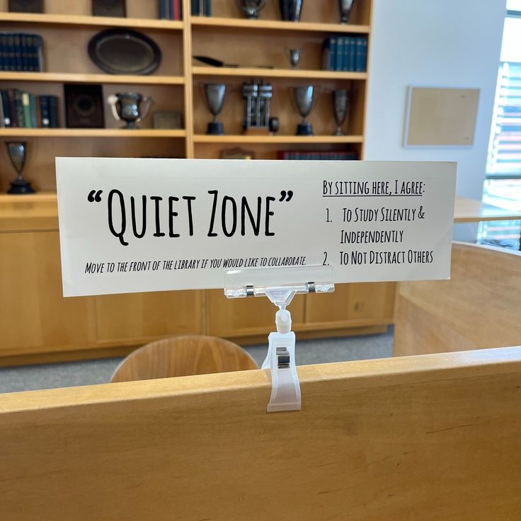 there is a sign that says quiet zone in the middle of a room with wooden shelves