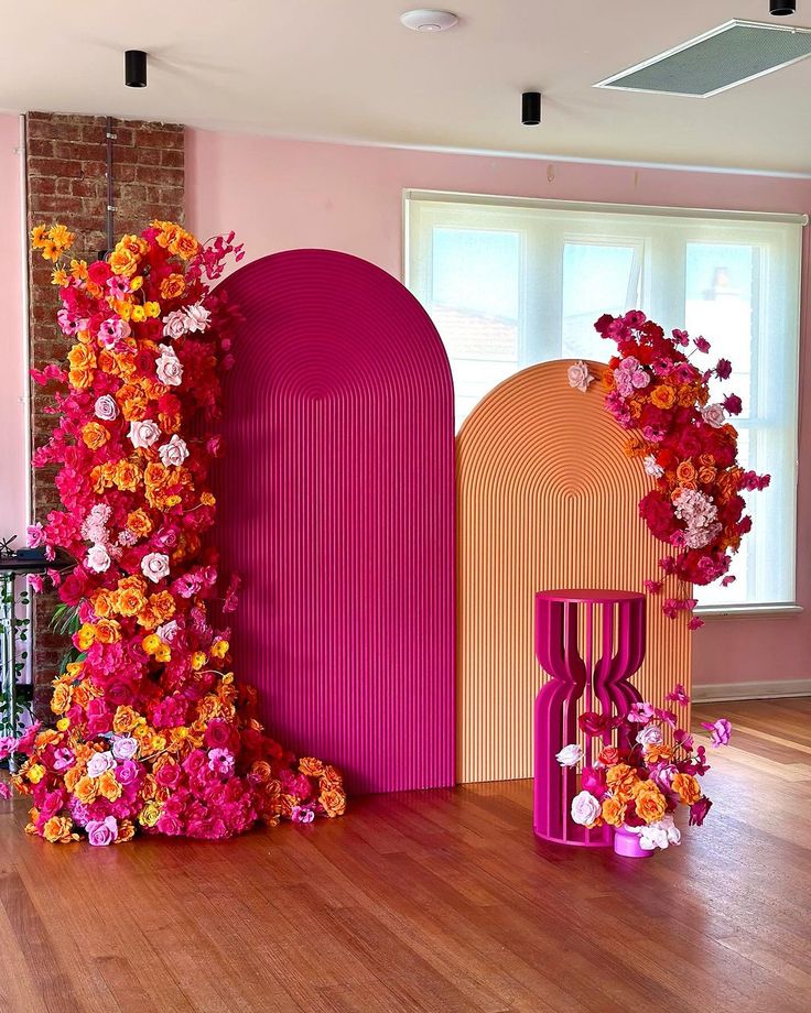 the room is decorated with pink and orange flowers, including an arch shaped like a letter