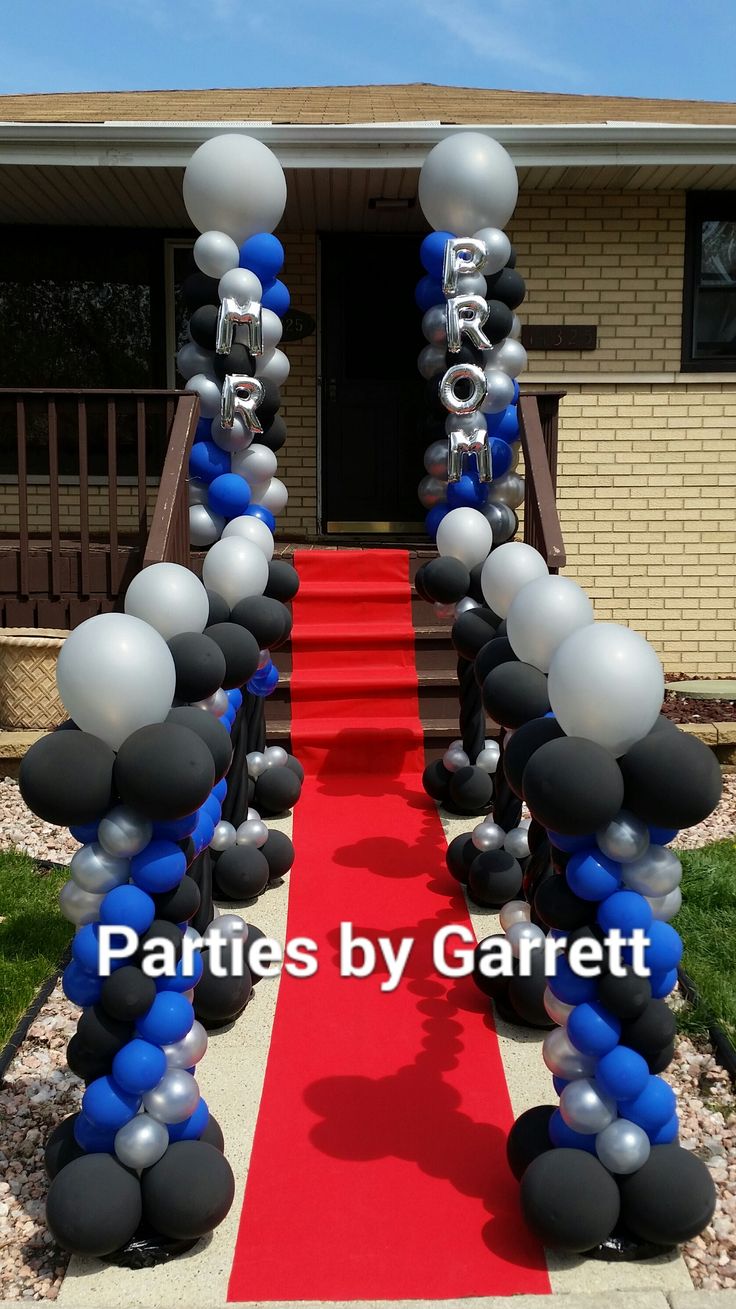 balloons and streamers are on the red carpet leading to an entrance for a party