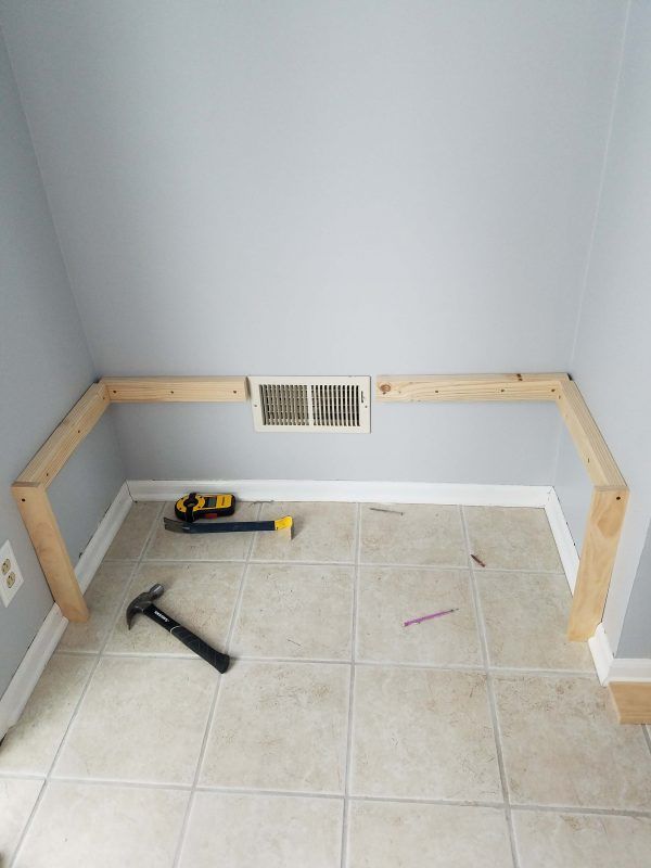 tools are laying on the floor in a room with gray walls and white tile floors