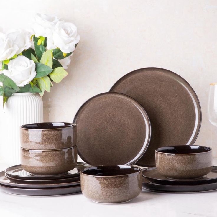 a table topped with plates and cups filled with flowers