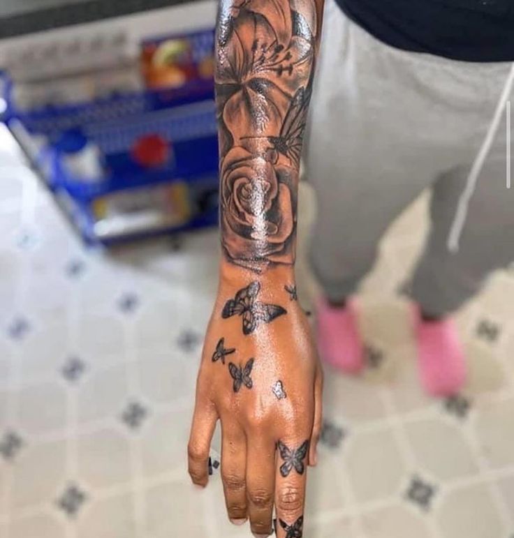 a person with tattoos on their arm and hand